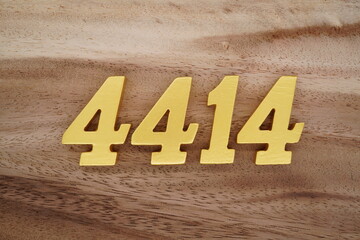 Golden Arabic numerals on a real brown and white wooden floor number 4414