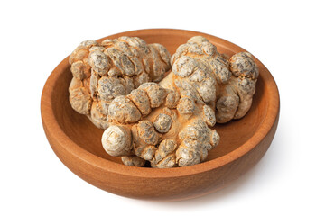 Dried notoginseng roots in the wooden bowl, isolated on the white background.