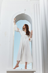 portrait of a woman in a white dress window opening luxury romance