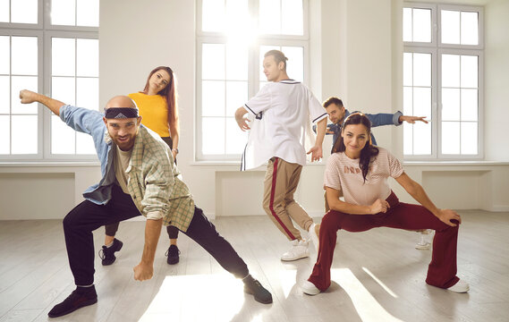 Portrait of happy diverse young dancers in casual clothes training together in modern studio. Smiling millennia dancing group perform prepare for concert. Artists performance, hobby concept.