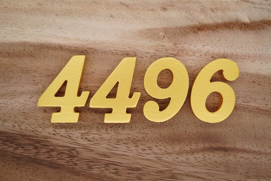 Golden Arabic numerals on a real brown and white wooden floor number 4496