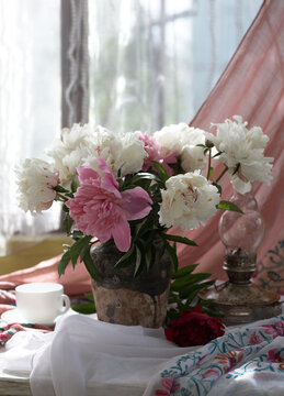 Still life with white and pink peonies in a old ceramic vase