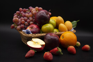 Various seasonal fruits of Thailand in appetizing colors in a basket on black background.Include Clipping Path.
