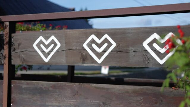 Ornamental traditional Slovakian symbols are painted on a wooden rural village house in Čičmany, Slovakia, worlds cultural heritage, a famous landmark in central Europe, plants revealing wooden fence