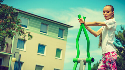 Girl training on public equipment