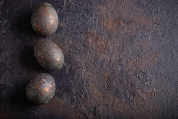 Easter hibiscus tea-dyed chicken eggs on a dark grunge background. Copy space. Top view - 495597522