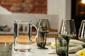 glass wine glass with clean drinking water in the kitchen in the interior of the loft space.