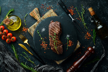 Beef Sirloin steak. Juicy cooked steak with rosemary and spices. Top view. Rustic style. Flat Lay.