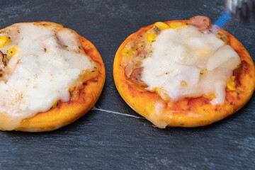 ガスバーナーでピザのチーズを炙ります