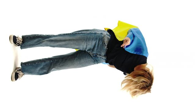 Vertical shot Woman with blue and yellow flag of Ukraine on her back. Independence of Ukraine.