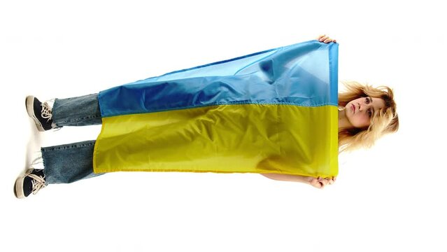 Vertical shot. Worried girl holds Ukrainian flag. Blue and Yellow.War of Ukraine. Manifestation