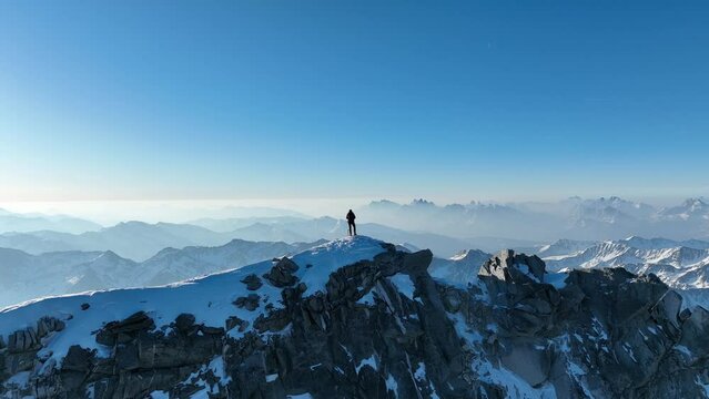 Mountaineer with ice axe standing on a mountain ridge in the Italian Alps. Monte Collalto, Vedrette di Ries.