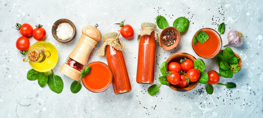 Tomato cocktail. Two tomato juice in a bottle. Top view. On a stone background.