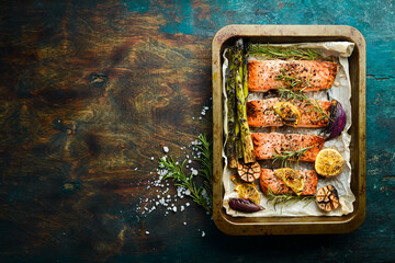 Pieces of grilled salmon in a metal tray with vegetables and rosemary. Recipe. Seafood. Free space...