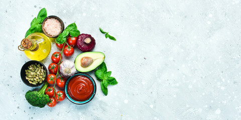 Bowl with tomato paste and ingredients for cooking, on a gray stone background. Ketchup. Top view. Free space for text.