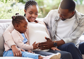 They couldnt be happier. Cropped shot of an attractive young pregnant woman sitting on the sofa at home with her husband and daughter. - obrazy, fototapety, plakaty