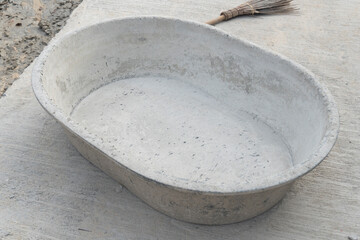 Empty mortar mixer. Place it on a concrete floor and have a broom on the side.