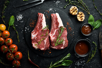 Veal. Raw veal steak on the bone, on a black stone background. Meat.