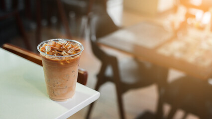 Ice coffee on a plastic cup with cream being poured into it showing the texture