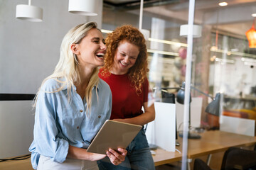 Happy successful young business colleagues working in office. Business people technology concept