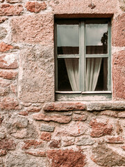 An old wood and glass window isolated on rough stonewall, space for your text or logo