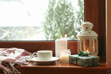 Composition of cozy winter day on wooden windowsill