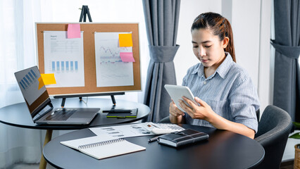 Business woman looking on tablet to checking email and reply information to boss while reading business chart