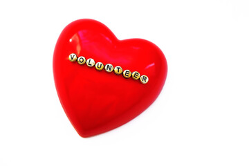 Word  Volunteer on red heart, White background.