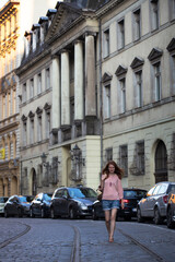 a girl walks through the streets of an old European city