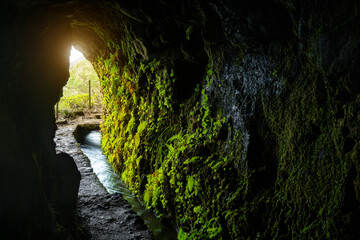 Light at the end of the tunnel on the path by the levada water canal on the Madeira Island, Portugal.