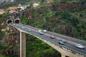 Traffic on the overpass over one of the valleys of Madeira. Typical highway transport combination - tunnels and bridges.