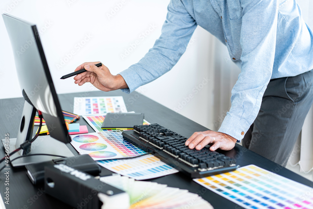 Fototapete young creative graphic designer working on color selection and drawing on graphics tablet at workpla