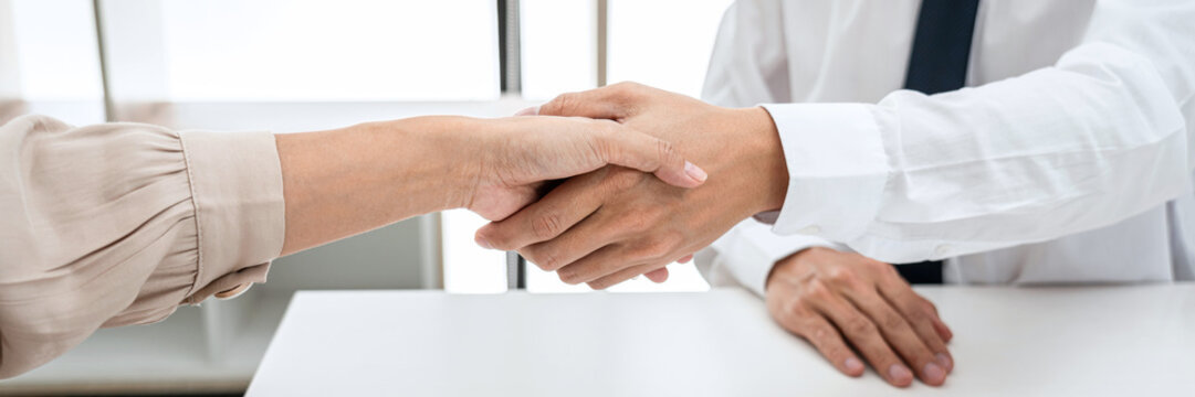 Woman employer is shaking hands to congratulate with the new employee after successful with job interview