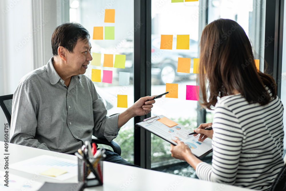 Poster business team pointing on keywords in sticky notes and business report to brainstorming about planni