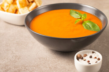 Fresh, healthy tomato soup with basil, pepper, garlic, tomatoes and bread on wooden background. Spanish gazpacho soup. Lentils and pumpkin soup.