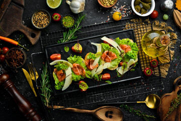 Bruschetta with salmon, lettuce and parmesan cheese on a black plate. Top view. Rustic style.