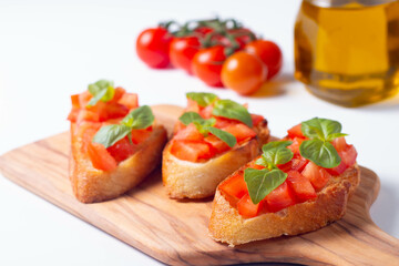 Italian tomato and cheese bruschetta. Tapas, antipasti with chopped vegetables, herbs and oil on grilled ciabatta and baguette bread.