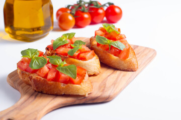 Italian tomato and cheese bruschetta. Tapas, antipasti with chopped vegetables, herbs and oil on grilled ciabatta and baguette bread.