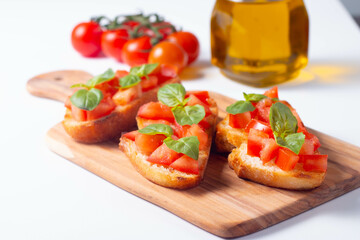 Italian tomato and cheese bruschetta. Tapas, antipasti with chopped vegetables, herbs and oil on grilled ciabatta and baguette bread.