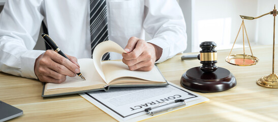 Male lawyer working with litigation contract paper documents of the estate lawsuit, Law books and...