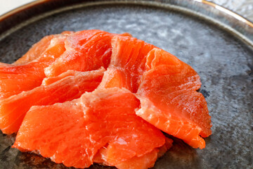 黒いプレートに盛り付けたスモークサーモン