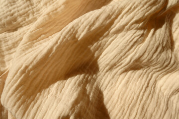 Lightweight beige cotton muslin fabric in soft folds