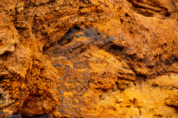Textural sand, with  relief surface, multi-colored layers and different in size of granules, in outdoor sand career, after mining ore and sand for construction.