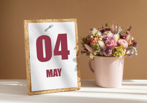 may 4. 4th day of month, calendar date.Bouquet of dead wood in pink mug on desktop.Cork board with calendar sheet on white-beige background. Concept of day of year, time planner, spring month