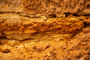 Textural sand, with  relief surface, multi-colored layers and different in size of granules, in outdoor sand career, after mining ore and sand for construction.