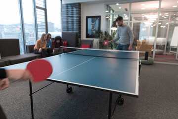 Two young start up business man playing table tennis at modern creative office space people group...
