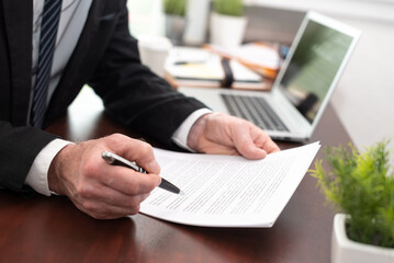 Businessman reading and checking document (Lorem ipsum text used)