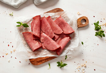 Beef pastrami slices on cutting board - obrazy, fototapety, plakaty