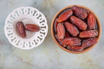 Bowl of dates fruit on colorful marble background, directly above