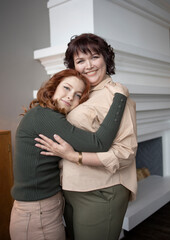 friendly family of women, European appearance, mother and daughter hugging, in the room. Happiness, tenderness, care, mother's day, protection of women, support.